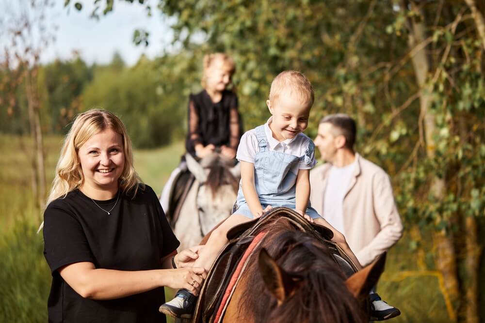 Best Family Resorts in North Carolina: A family is horseback riding at Leatherwood Mountains Resort